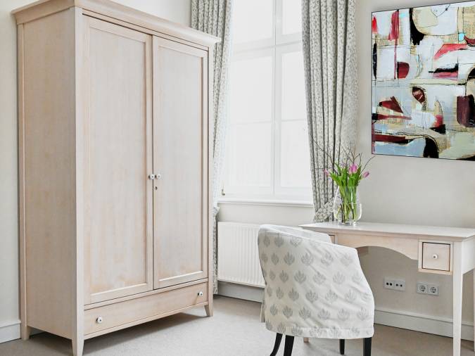 Ein Zimmer mit einem Schreibtisch und einem Stuhl, der eine gemütliche Arbeitsatmosphäre schafft.